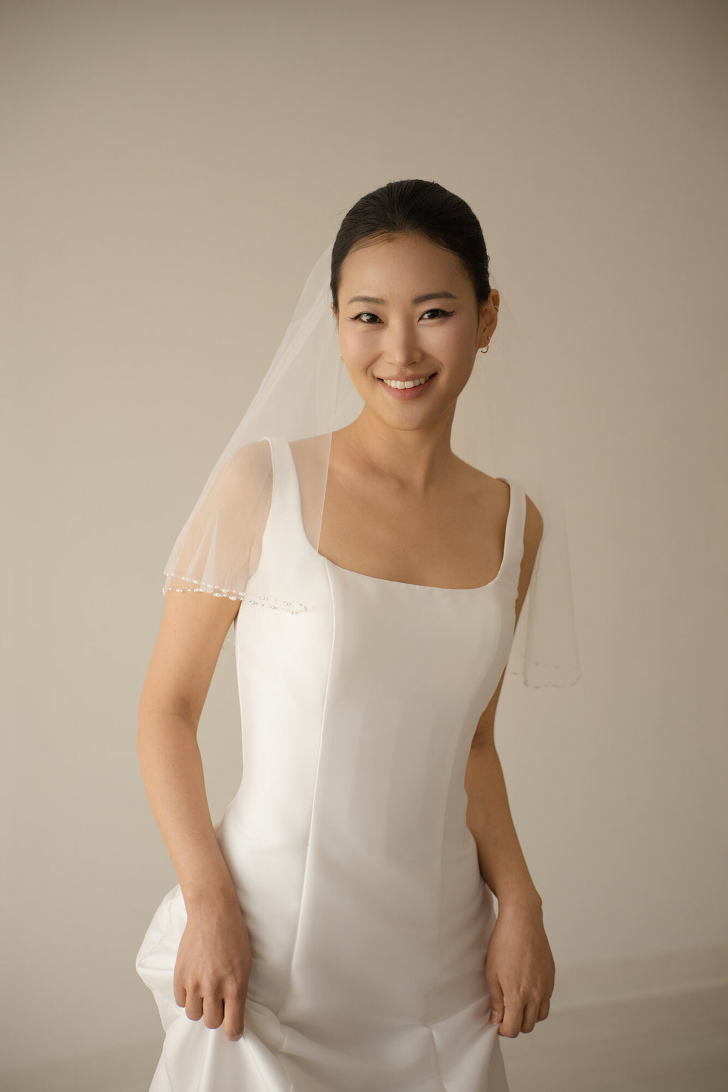 The Second Look two tier pearl blusher veil at shoulder length, worn back over a square neckline white gown