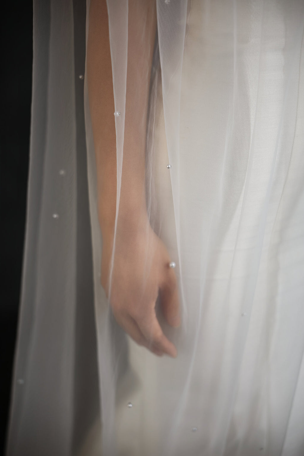 Close detail of The Soft Focus veil showing individual pearls scattered across sheer bridal tulle