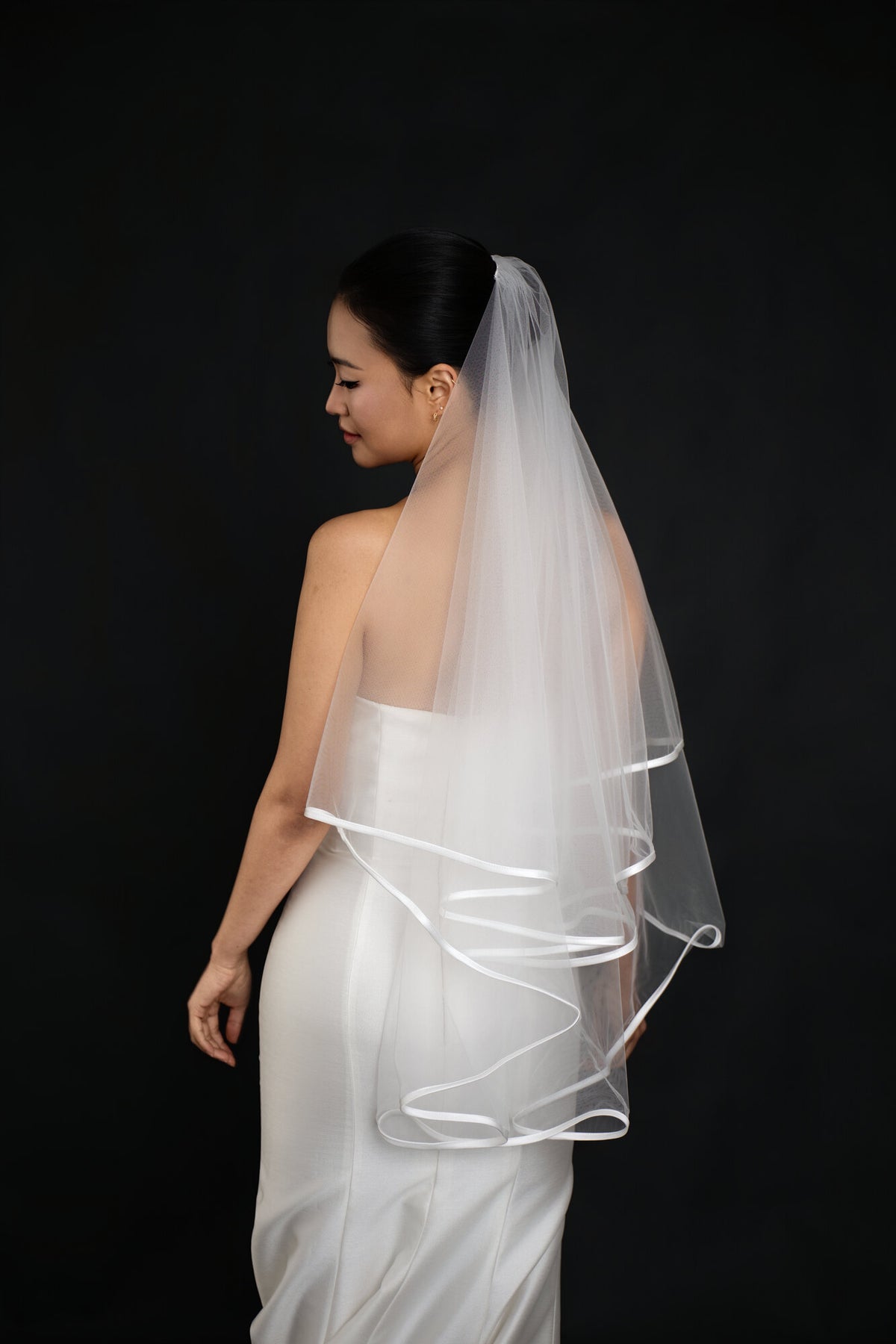 Side and back view of The Clean Line two tier veil showing how the satin ribbon edge traces the outline of both layers