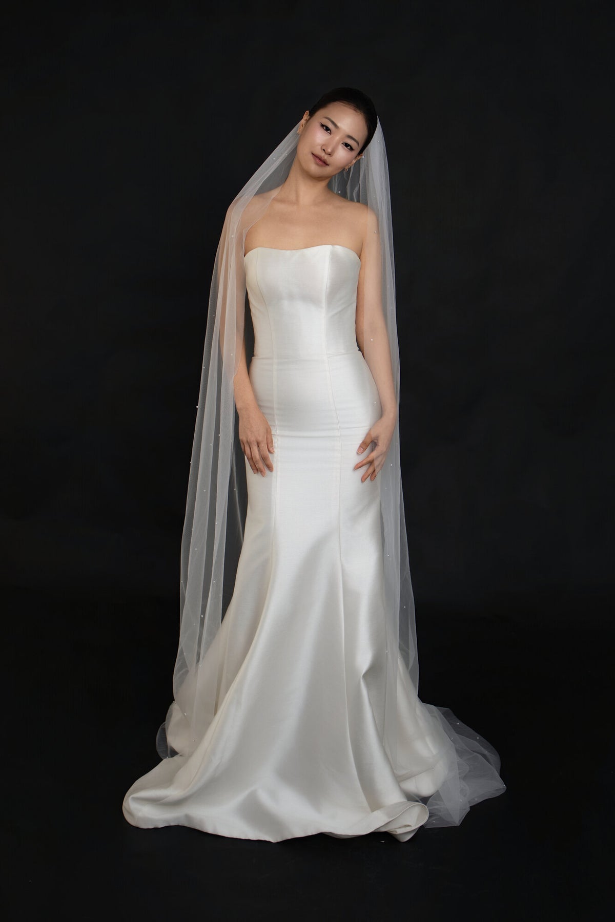 Full length front view of The Soft Focus scattered pearl cathedral veil falling past the hem of a fitted white gown