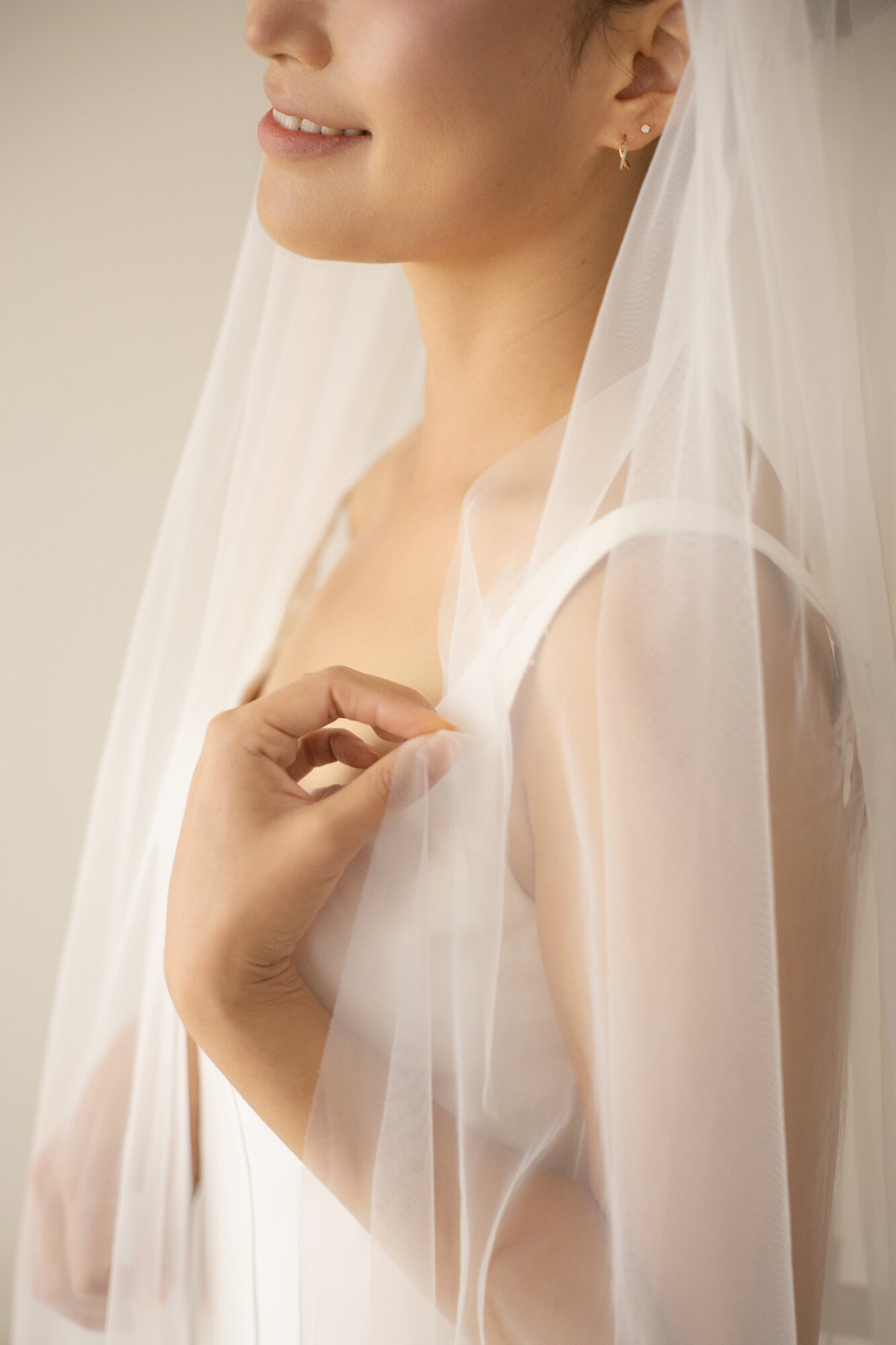 Close detail of The Barely There veil showing the raw cut edge and the transparency of the soft bridal tulle over the shoulder